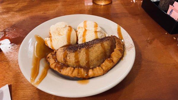 Fried apple pie with ice cream and caramel drizzled on top