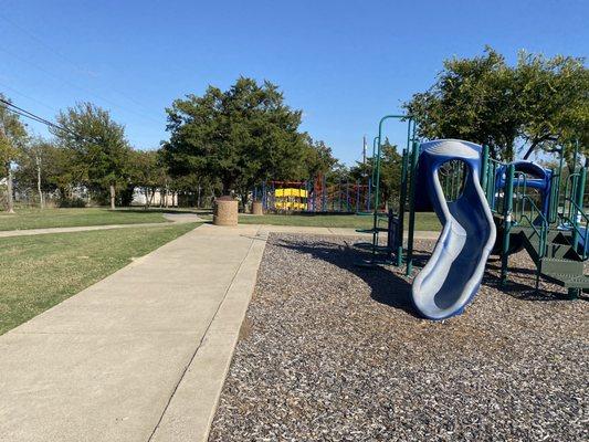 Smaller playground in the foreground, playground for older kids in the background