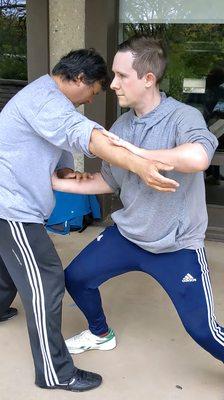 Tai Chi partner training Pushing Hands (Tui Shou). This trains sensitivity and timing for applying the martial techniques of Tai Chi