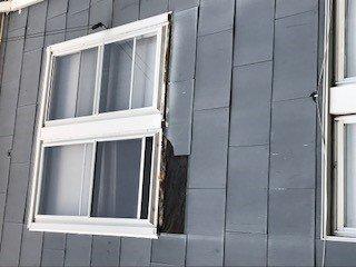 exterior of the house with missing shingle which leads to hole inside the house. has been like this for three months.