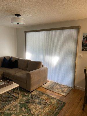 Family room with Platinum color vertiglide duette honeycomb shades