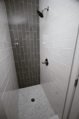 Showers don't need to be elaborate, just designed right. This simple design with subway tile and a pebble floor is aesthetically-pleasing.