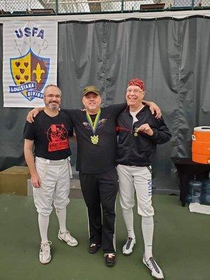 Three of our veteran fencers at a tournament in New Orleans.  Our own coach is in the picture.  Can you spot him?