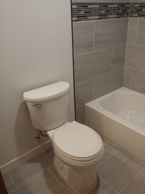 Tiled floor, set new toilet and bathtub, and tiled shower