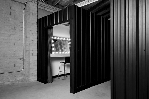 Dressing room area featuring a vanity mirror and makeup chairs.