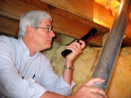 Jeff examining an attic for water damage