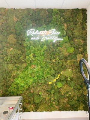 one of the many accent walls here at Radiant Skin and Beauty. It is covered in preserved moss with an LED light with our name on it.