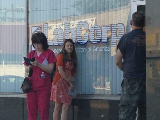 Line of people (including a nurse?) waiting to get in for their appointment while the staff was a no-show.