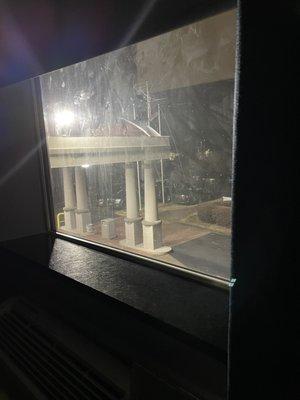 View from bed during middle of the night. Shade wouldn't lower more than this. Flood lights on hotel front completely illuminated room.