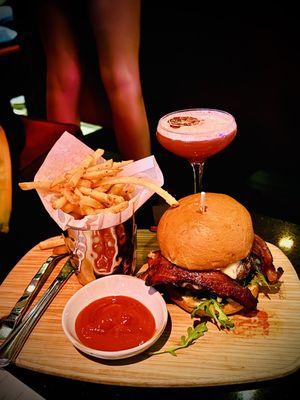 Wagyu Burger with crispy bacon, heirloom tomato, truffle Gouda, arugula, huckleberry spread, and pickles with truffle fries