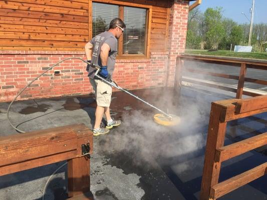 Steam cleaning patio at a Texas Road house before applying a sealer.