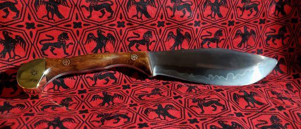 A custom knife with a wide-bellied kukri style blade and hamon