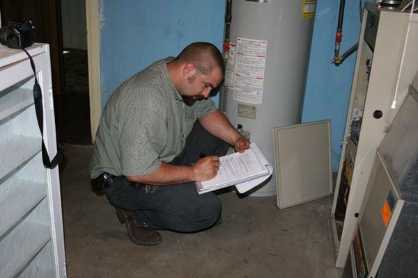 A certified mold inspector checking dark, damp areas for possible surface mold growth, as well as standing moisture.