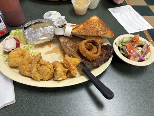 Steak and shrimp with baked potato and cucumber salad