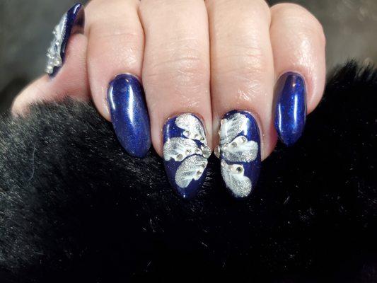 Beautiful blue nails with silver-white flowers and gems to add sparkle to your day!