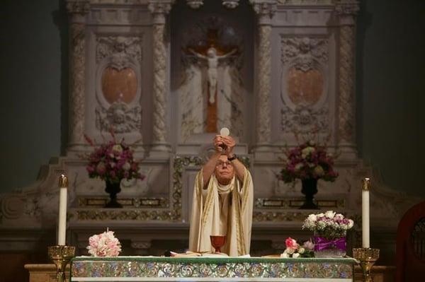 The gorgeous back altar floral arrangements. (Behind the priest.)