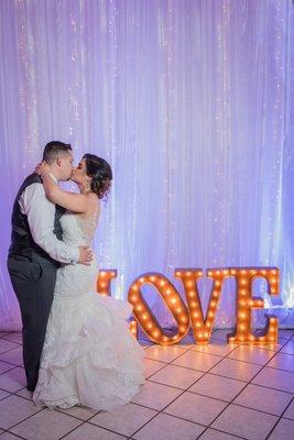 Grove Las Vegas wedding, couple kissing in front of the LOVE sign.