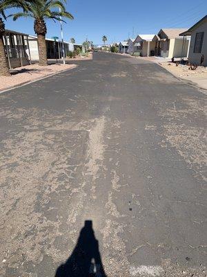 Streets are cracked asphalt, dirt, and rocks.