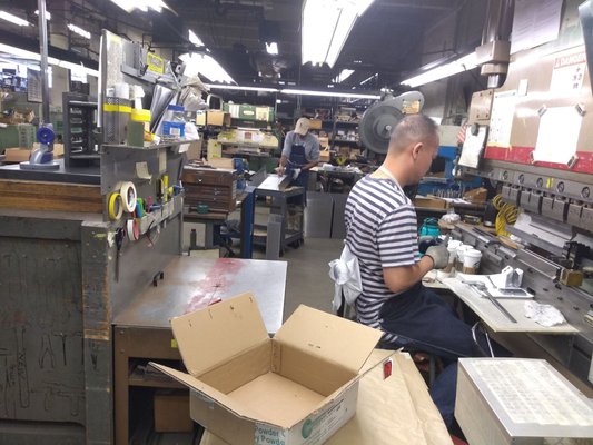 Employee at work on a metal-bending machine