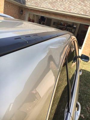 Basketball size dent above the rear glass on a Honda CR-V.