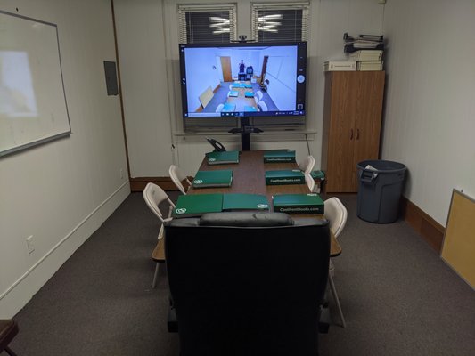 Advanced conference room setup utilized for training and certifications; contains wide screen TV, computer, web cam and controllable stand.