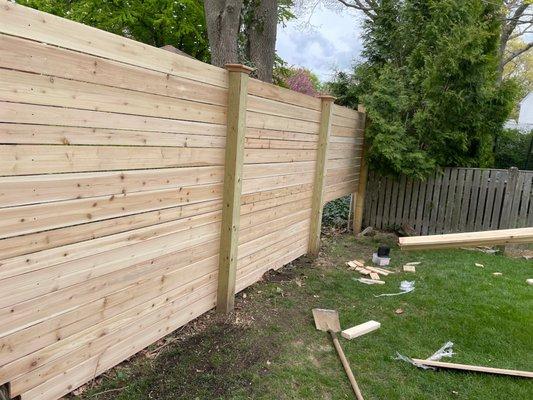 Final boards being installed for custom cedar fence.