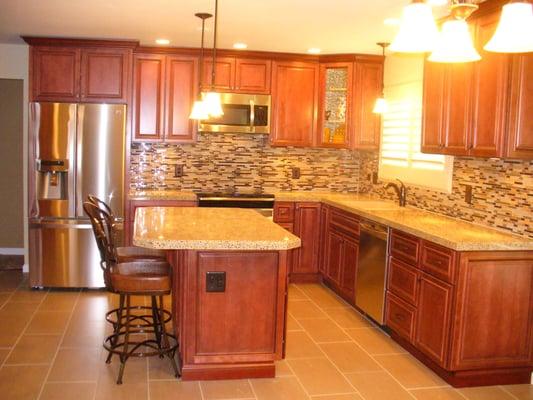 Glazed Cherry cabinets, recycled material countertop, tile backsplash, tile flooring and new lighting.