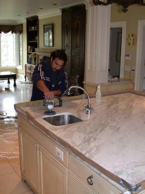 Diamond polishing a white marble counter top.