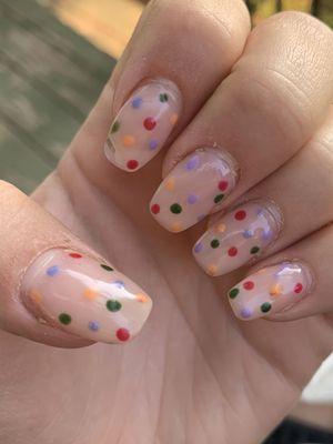 Chip on pointer finger, mixed colors on polka dots on multiple fingers