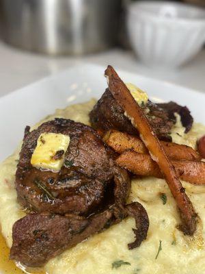 Bacon wrapped steak on a bed of creamy mash and roasted carrots