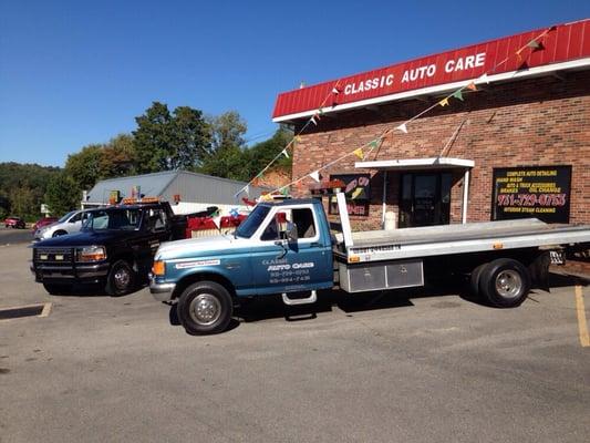 This is two of are trucks in front of the  shop