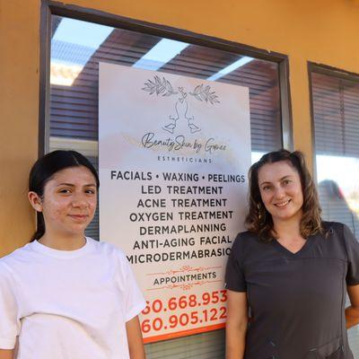 Carmen, the 
esthetician,  and a happy customer stand beside the service sign.