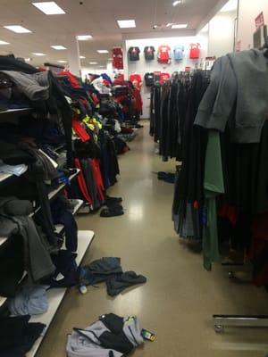 Men's sporting clothes - clothes on floor, over wracks, disarray on shelves.