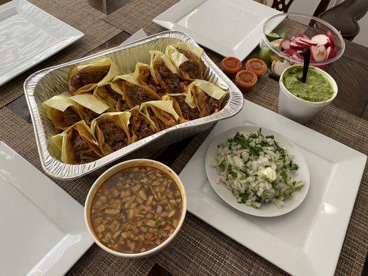 Tacos suaves plain con verdura a lado , cebolla cilantro, limones rábanos . Y un consomé grande .