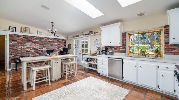 Country style kitchen with stainless steel appliance, stain window and French doors to the court yard.