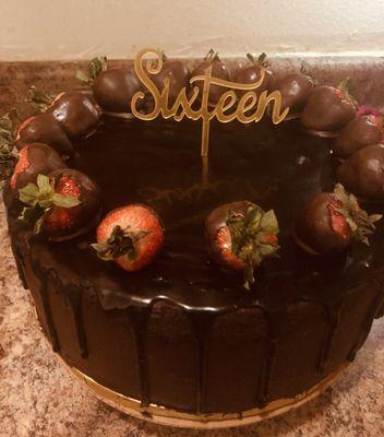 Rich chocolate cake covered in dark chocolate frosting accented with fresh chocolate dipped strawberries