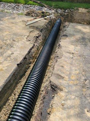 Installing a drain across the road.