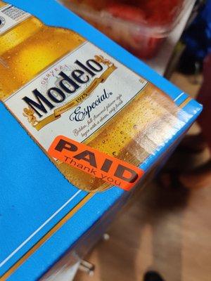 beer box with orange "PAID" sticker