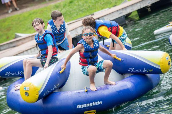 Cooling off with lake time -- swimming, inflatables and zip line.