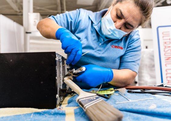 Technician cleaning electronics.