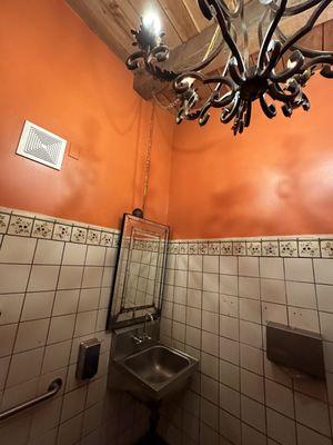 Restroom is like a gas station with a South of the Border paint job and chandelier