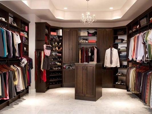 Walk-in closet designed with ClosetMaid MasterSuite wood laminate shelving in Chocolate Pear color