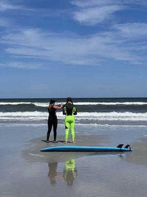 Instructor explaining the waves, tide, how to find a good wave, and reviewing safety before entering the water.