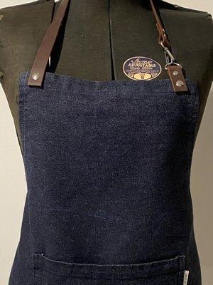 Denim apron with leather straps.