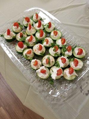 cucumber bites with herbed cheese, tomato and cilantro.