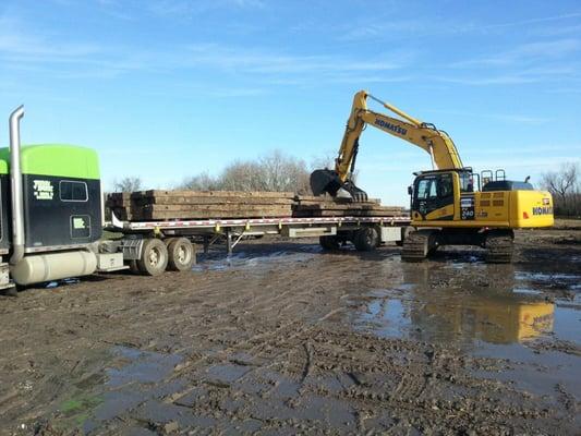 hardwood construction crane mats used being offloaded at a job site from a truck