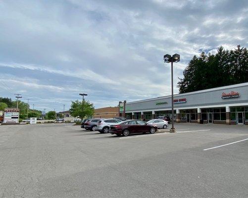 Entrance sign, parking lot, and storefronts