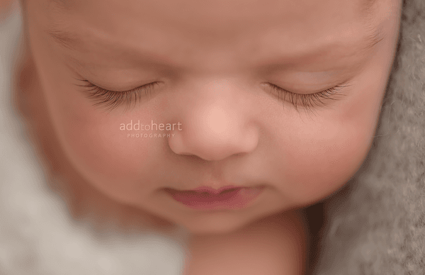 Closeup of newborn baby girl's eyelashes by Add to Heart Photography