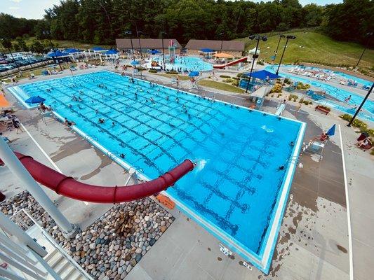 Overview of the lap pool with a waterslide, diving board, and diving platform.