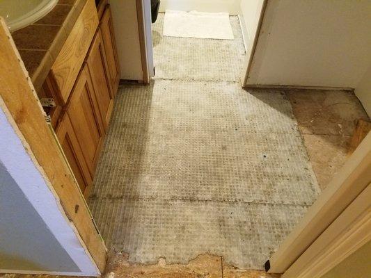 Bathroom where toilet flooded. Courtesy Restoration tore up the flooring and baseboards to help dry bathroom out.